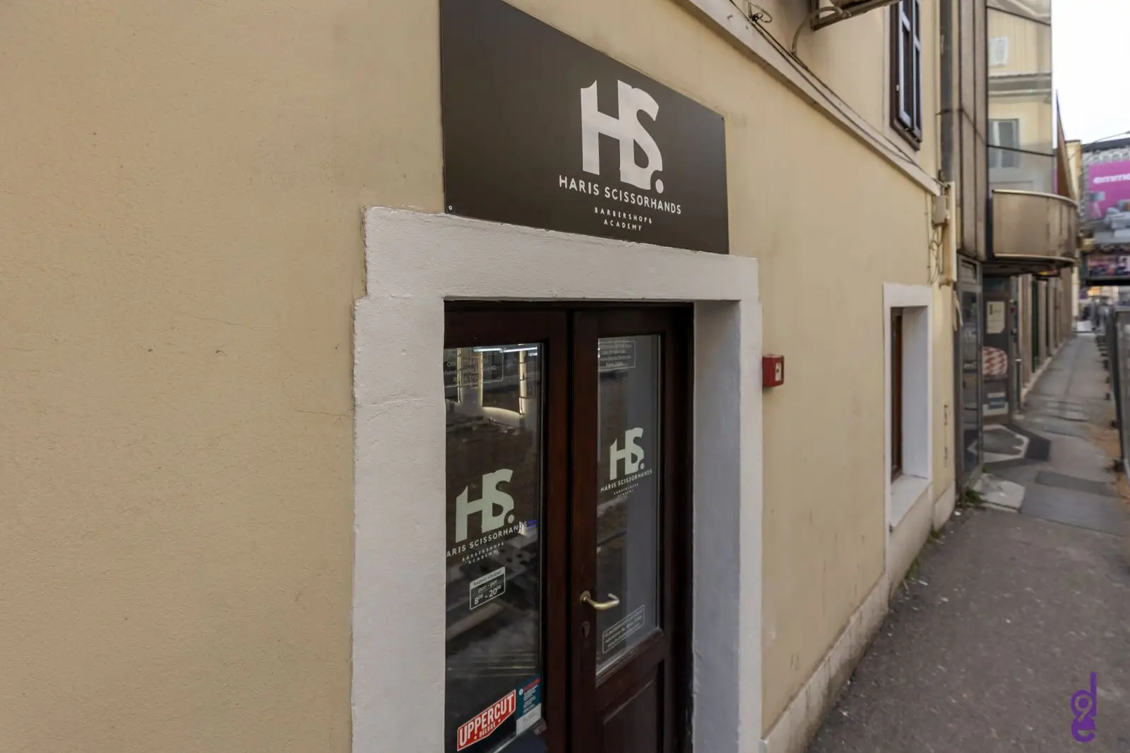 Ulaz u HS Barbershop, Adamićeva 5b, Rijeka: tamna vrata ispod natpisa HS. Haris Scissorhands Barbershop & Academy